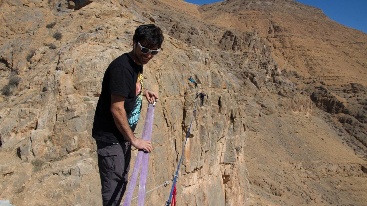 Man preparing a mountainside slackline
