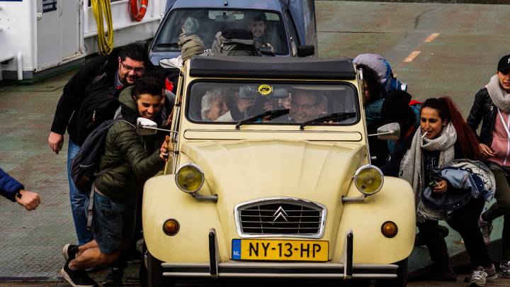 Keep pushing: Syrians help to get an old car started on a ferry across the river Meuse. 