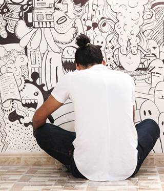 Designer Khaled Bader drawing a mural in the new Tanarout centre.