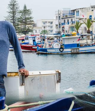 Jamel Mouhalib stands on his boat in the old port of Bizerte. 