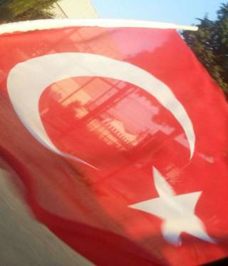 Türkische Fahne mit Gebäuden im Hintergrund