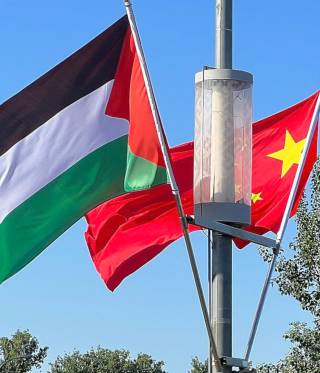 Chinesische und palästinensische Flagge wehen am Flughafen Bejings.