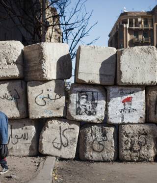 Youth clamber over a barrier in Cairo. 